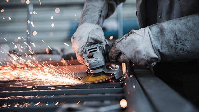 Man using a grinder in a manufacturing buisness